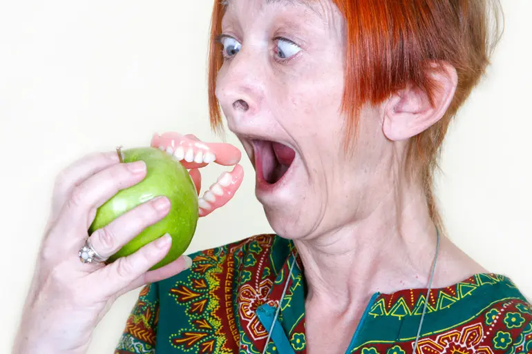 入れ歯が外れて驚く女性