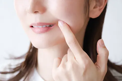 手鏡で口元を見て落ち込む人