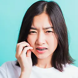 矯正装置の痛みに耐える女性