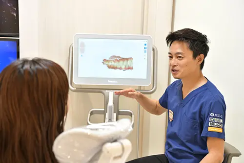 歯科医師がカウンセリングで治療計画を説明している様子