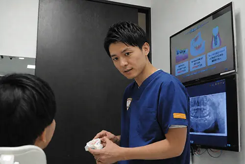 歯科医師が患者にレクチャーするイメージ