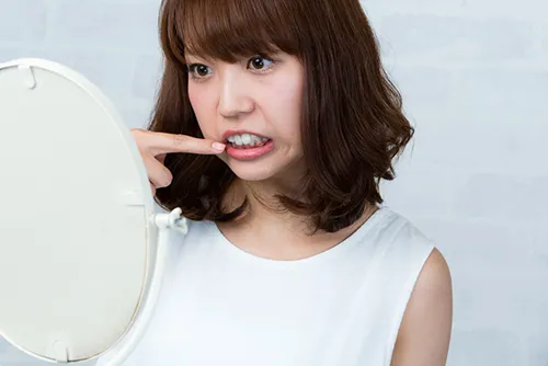 出っ歯をコンプレックスに感じている女性のイメージ