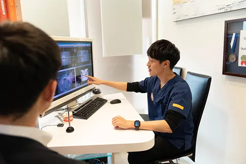 カウンセリングで治療計画やリスクを丁寧に説明する歯科医師のイメージ